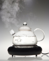 玻璃茶壶里烧开的热水正在冒热气