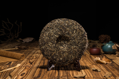 圆形中国普洱茶茶饼竖立在原木色桌面上的小场景