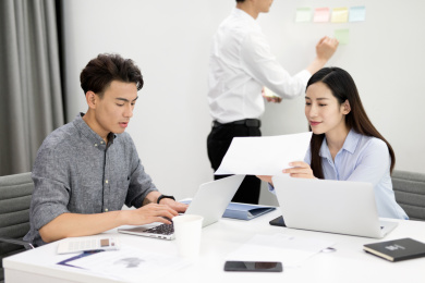 男性员工和女性员工就工作问题在会议室讨论