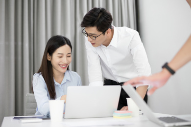 两位年轻的同事在办公室内讨论相关的工作问题