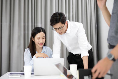 三名年轻公司职员在会议室里讨论相关工作问题