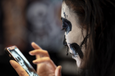 万圣节化妆舞会上玩手机自拍的女孩