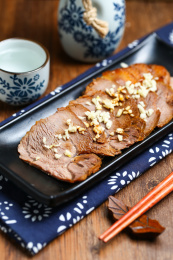 黑色盘子里的酱牛肉和白酒酒壶酒杯酒具放在木桌上