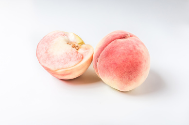 白色背景上露出果肉的新鲜美味的水蜜桃