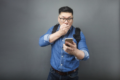 一位成熟的男人表情夸张的看着手机