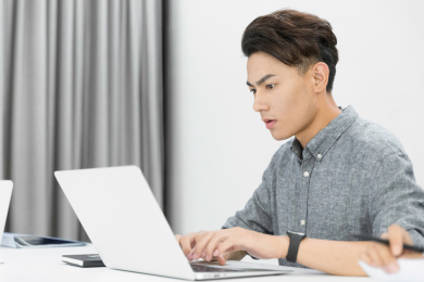 在办公室使用笔记本办公的男职员