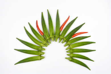 扇形的摆在白色背景上的绿色蔬菜秋葵及小辣椒