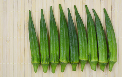 整齐地摆在竹盖帘上的绿色蔬菜秋葵