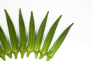 扇形摆在白色背景上的绿色蔬菜秋葵