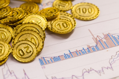 黄金金币与经济数据报表背景金融类静物特写