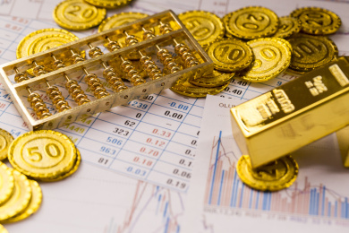 黄金金币与经济数据报表背景金融类静物特写