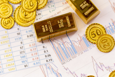 黄金金币与经济数据报表背景金融类静物特写