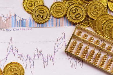 黄金金币与经济数据报表背景金融类静物特写
