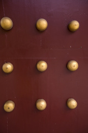 古代寺庙红色大门上的黄色门钉背景特写