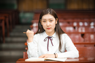 一个中国女大学生单手握拳为考试的同学鼓舞鼓励与加油