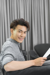 坐在沙发上的商务男士看向镜头面带微笑
