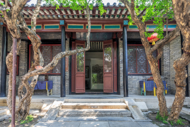 中式古建筑前的弯曲的树干，中国山东省潍坊市十笏园