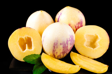 黑底上的三个完整的人参果和两个切开的人参果和两块人参果果瓣