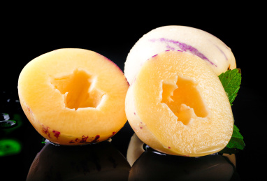 黑底上的一个完整人参果前放着两个切开的人参果