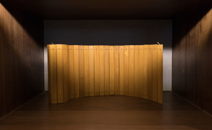 书柜上竖立摊开的一份空白竹简