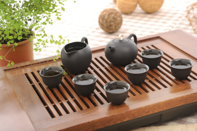 墨绿色陶瓷茶具在木质复古茶盘上，中国茶道场景