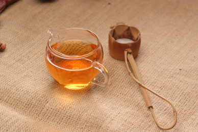 透明玻璃茶杯在亚麻布餐垫上，喝红茶场景