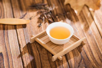 白色中国瓷器茶杯放在原木色茶盘上
