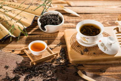 白色瓷器盖碗茶茶杯放在木质功夫茶茶盘上，中国功夫茶冲泡场景