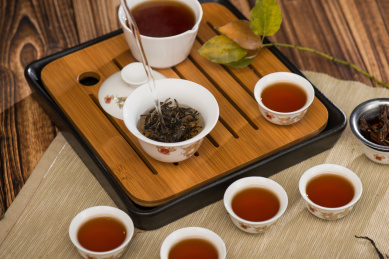 五个中国式样白色瓷器茶杯放在茶盘上，中国功夫茶冲泡场景