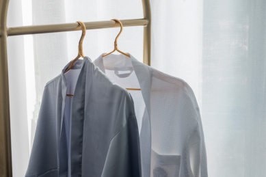 白色纱帘前衣架上悬挂的衣服