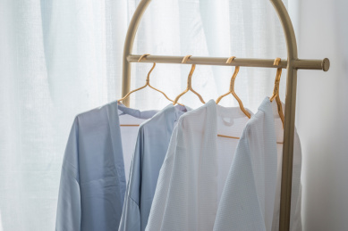 白色纱帘前衣架上悬挂的衣服