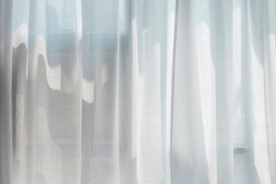 阳光照射下光影斑驳的白色纱帘