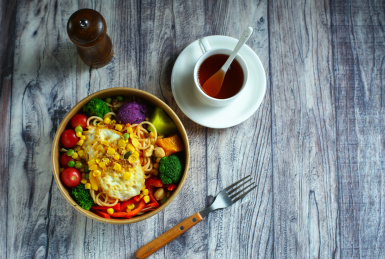 番茄沙拉意面和咖啡放在木桌上