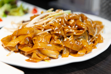 黑色餐桌上的一盘港式牛肉炒河粉