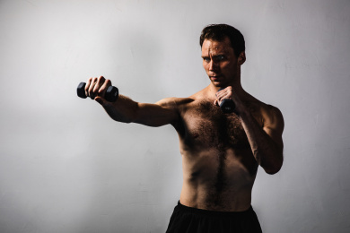 背景分离特写裸露上半身肌肉线条清晰的男性握着哑铃在打拳