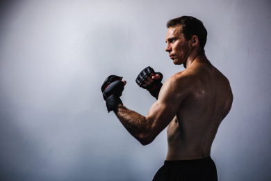 背景分离特写上半身裸露的英俊男性戴着拳套在挥拳