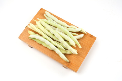 新鲜芸豆放在竹板上在白色背景前