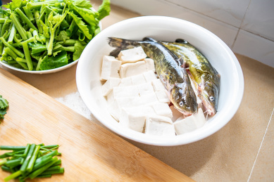 厨房台面上准备烹饪的新鲜食材豆腐煮黄骨鱼和南瓜藤