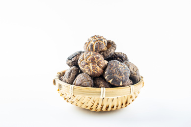 白背景上竹筛子装满晒干的真菌食材香菇