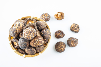 白背景上竹筛子装满晒干的真菌食材香菇