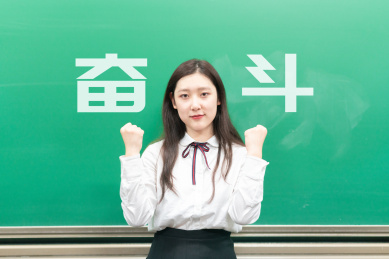 一位站在黑板前说着加油奋斗坚持拼搏的美丽中国亚洲女学生