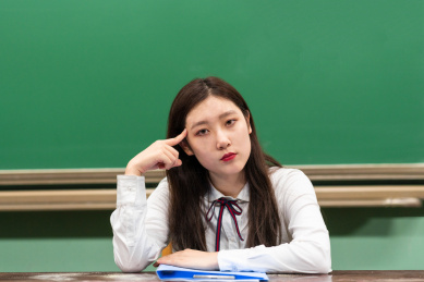 校园教室内,黑板前,一个正在思考的女大学生