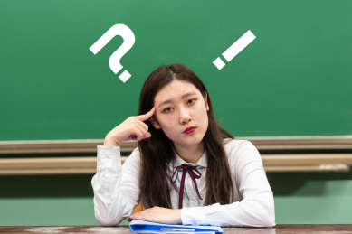 校园教室内,黑板前,一个正在思考的女大学生