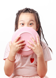 手拿着粉色盘子盖着嘴巴的小孩