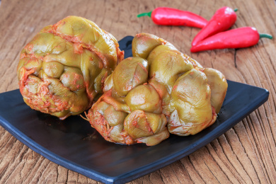 桌面上餐碟里的两个腌榨菜头