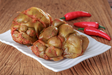 桌面上餐碟里的两个腌榨菜头