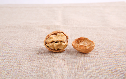 一堆黄色的中国核桃放在复古的麻布上