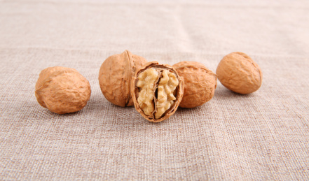 一堆黄色的中国核桃放在复古的麻布上