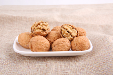 一堆黄色的中国核桃放在复古的麻布上