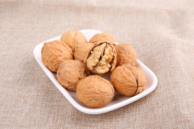 一堆黄色的中国核桃放在复古的麻布上